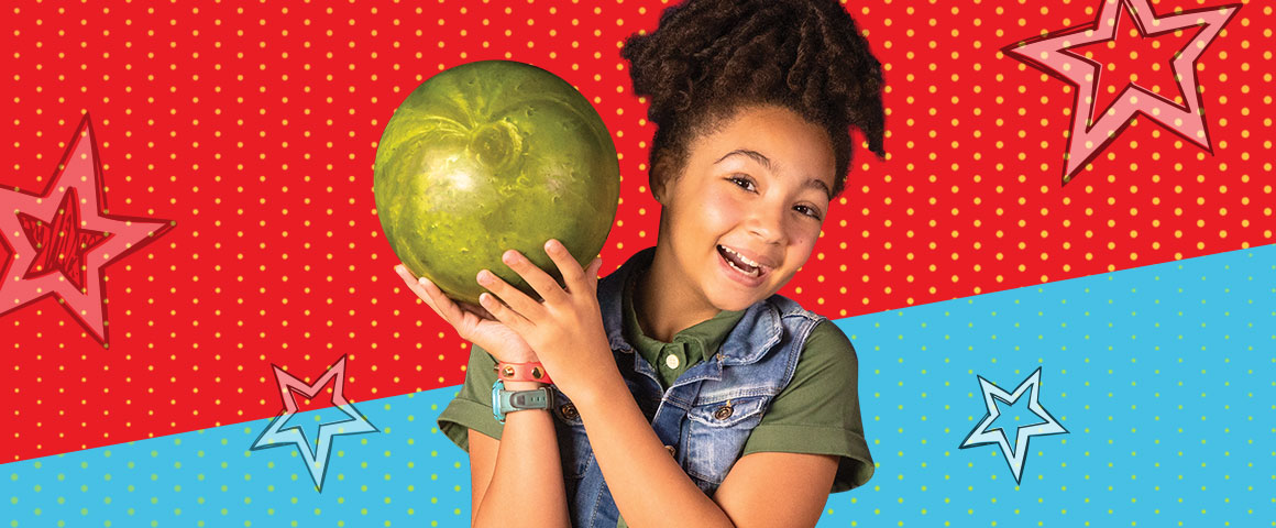 little girl holding a bowling ball smiling with a red and blue star background