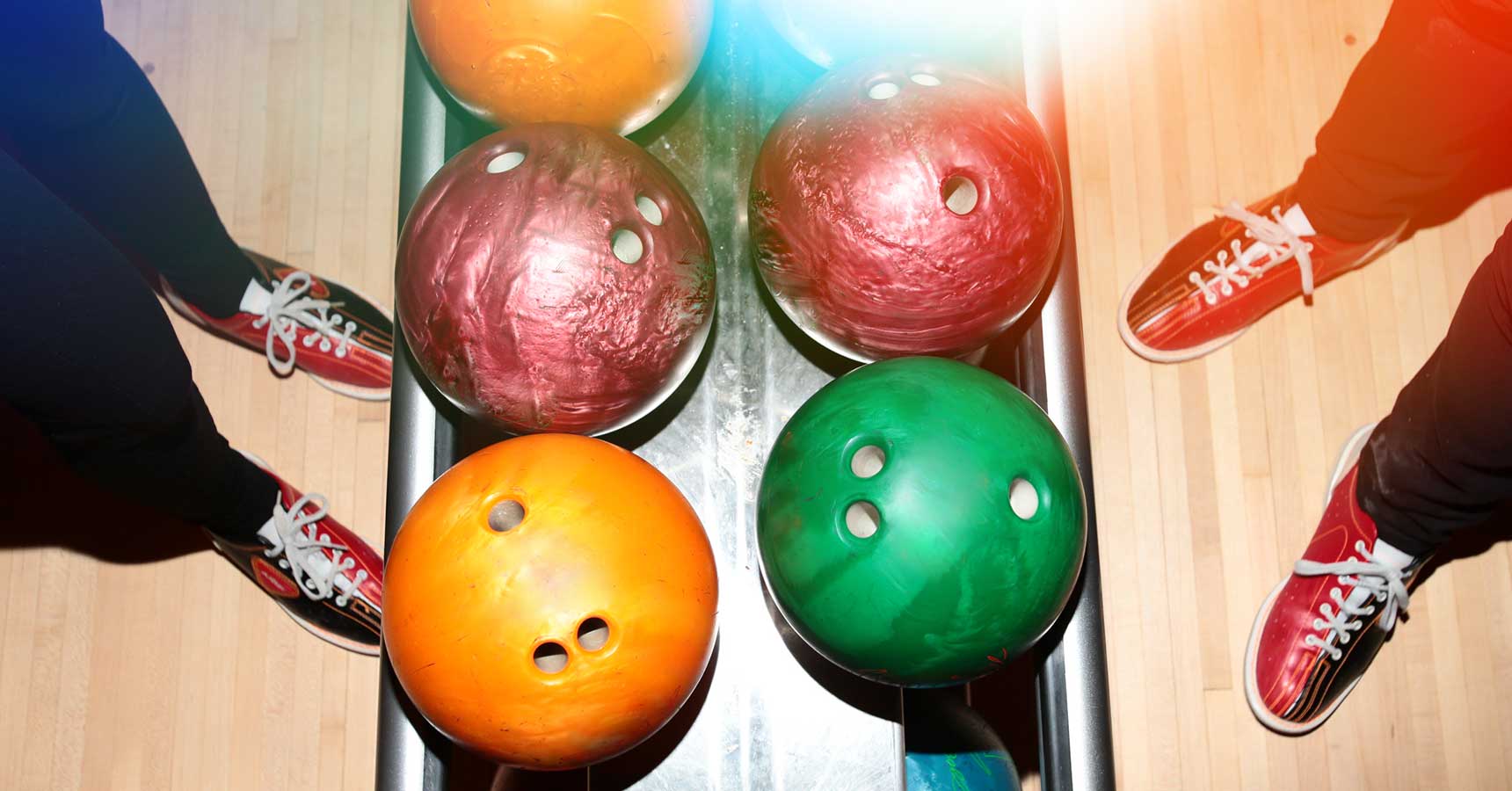 Looking down on ball return with bowling shoes on the sides