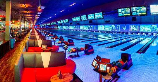Wide angle shot of a bowling alley with neon lights