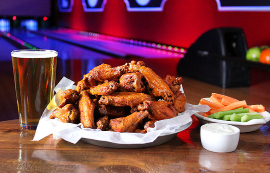 buffalo wings with carrots, celery, dressing, and a beer.