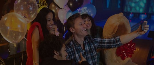 Friends taking a selfie on the lanes at a birthday party