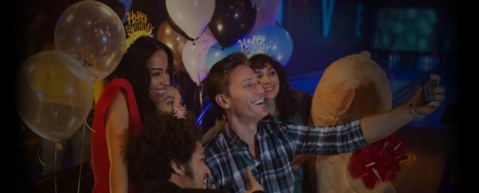 Friends taking a selfie together at a birthday party on the lanes