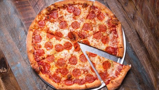 Pepperoni pizza pie on a wood surface