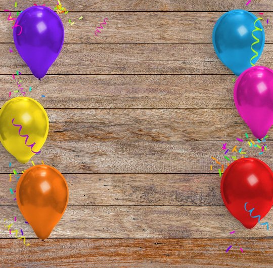 Balloons and confetti on a wood background