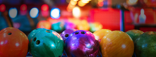 Brightly colored bowling balls in racks