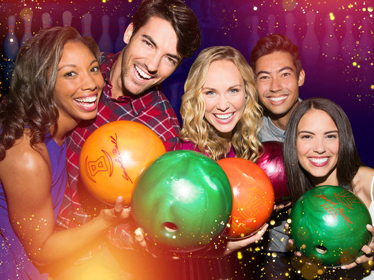 group of people holding bowling balls
