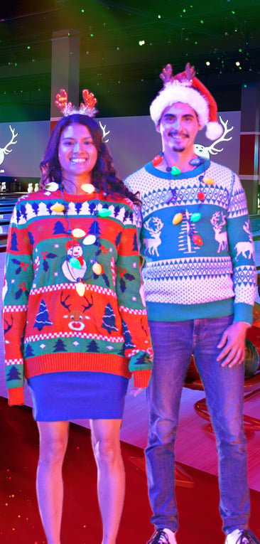 two people in holiday sweaters