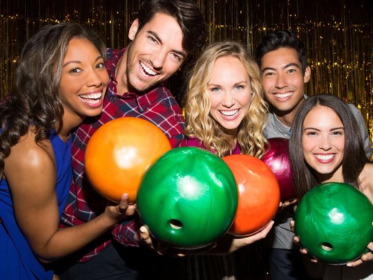 group of people holding bowling balls