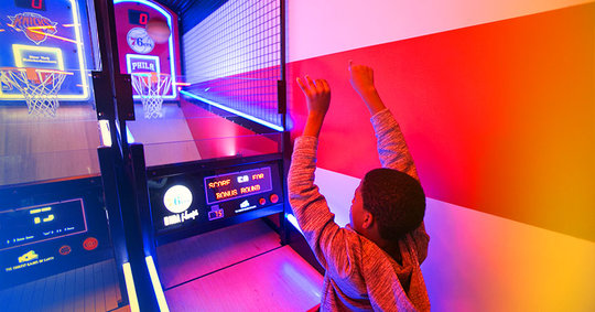 boy playing at the arcade basketball game