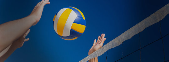 two people reaching up for a volleyball, over a net
