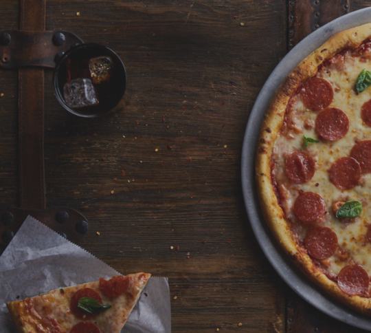 background image of pizza and pizza cutter on wood