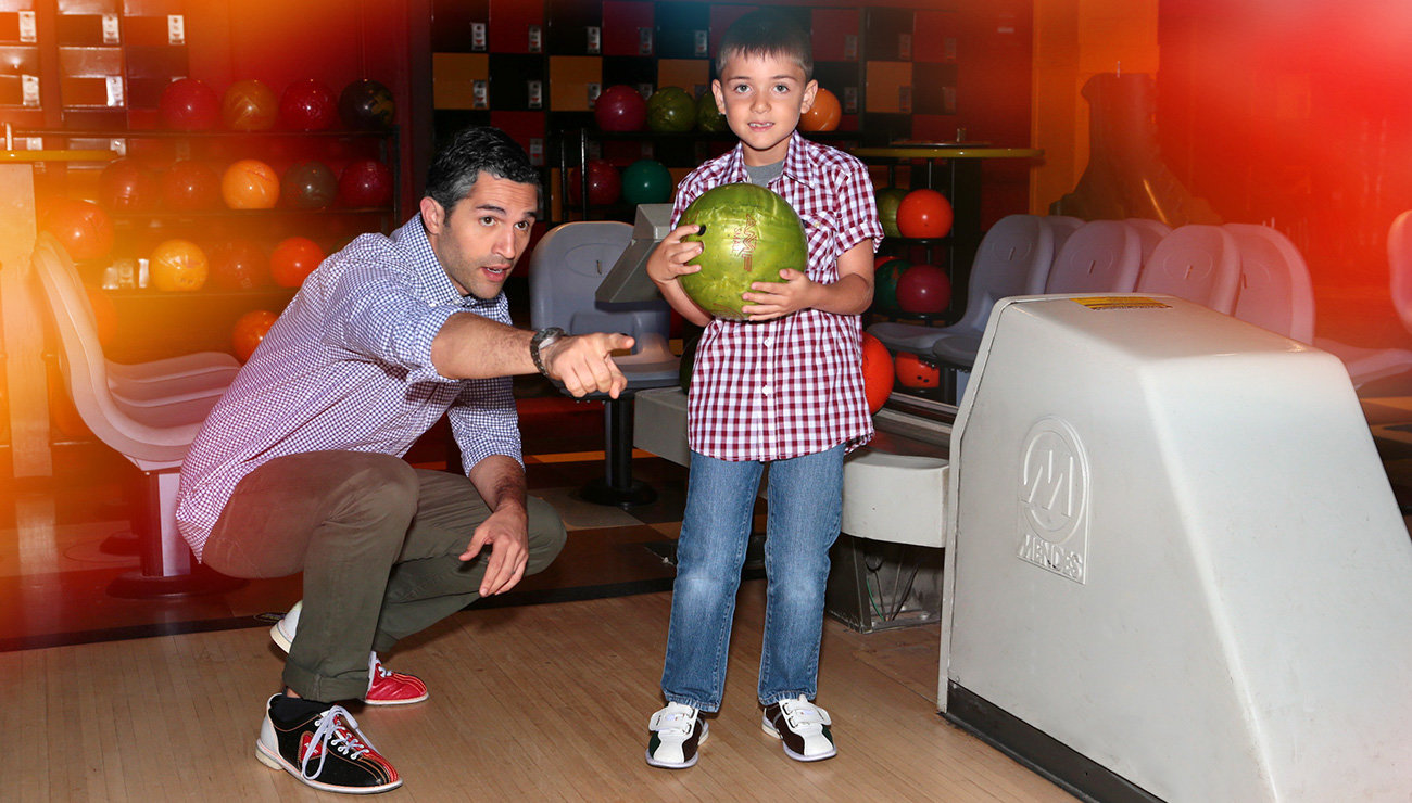 Dad showing son how to bowl