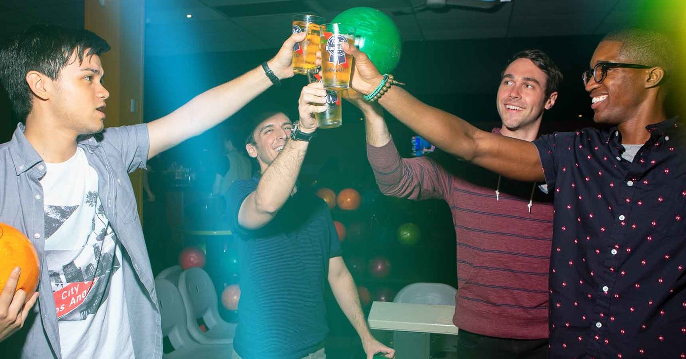 Four league bowlers clinking beers together on the lanes